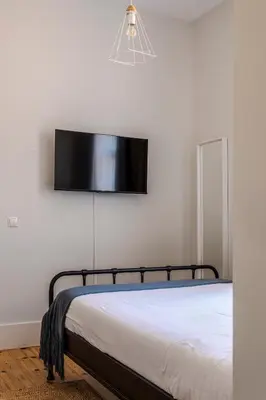 a bedroom with a bed and a flat screen tv on the wall at Viela Chic by Cozy Stay in Porto