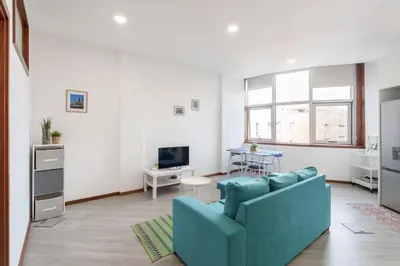 a living room with a blue couch and a table at VIVA Cozy Nest Studio Porto in Porto