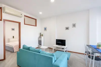 a white bedroom with a bed and two night stands at VIVA Cozy Nest Studio Porto in Porto