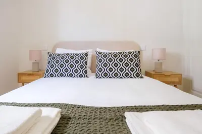 a bedroom with a white bed with pillows and two lamps at Art Deco 11 Luxury 2BR Apartment Downtown Metro AC in Porto