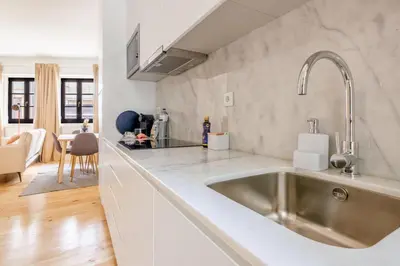 a kitchen with a stainless steel sink and white cabinets at Art Deco 11 Luxury 2BR Apartment Downtown Metro AC in Porto