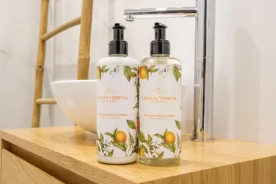 two bottles of lemon therapy on a wooden shelf at Art Deco 11 Luxury 2BR Apartment Downtown Metro AC in Porto
