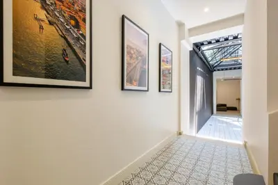 a hallway with paintings on the walls of a house at Art Deco 11 Luxury 2BR Apartment Downtown Metro AC in Porto