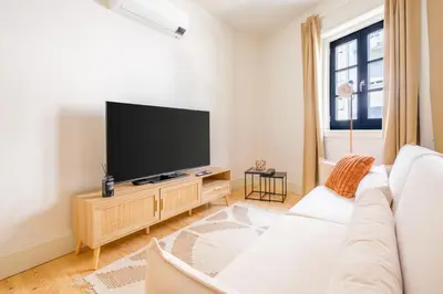 a living room with a white couch and a flat screen tv at Art Deco 11 Luxury 2BR Apartment Downtown Metro AC in Porto