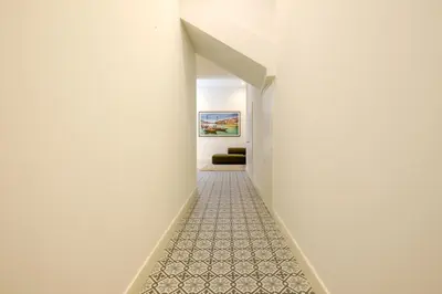a hallway with white walls and a carpeted floor at Art Deco 21 Luxury 2BR Apartment Downtown Metro AC in Porto