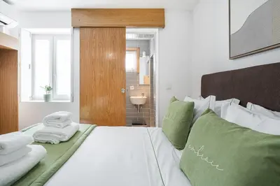 a bedroom with a white bed with green pillows at GuestReady - Invicta Porto Guest House in Porto