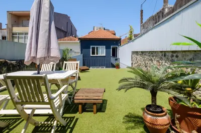 a patio with an umbrella and a table and a chair at Bonfim Garden Apartment Near Metro & City Center in Porto