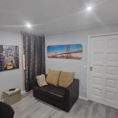 a living room with a black couch and a white door at Miragaia Charm Apartment in Porto