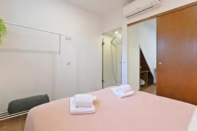 a bedroom with a pink bed with towels on it at Casa do Palácio 16 e 17 in Porto