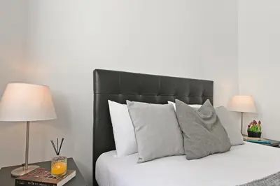a bedroom with a bed with a black headboard and pillows at Casa do Palácio 16 e 17 in Porto