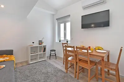 a living room with a table and chairs and a tv at Crystal Palace House - T2 - D13 in Porto