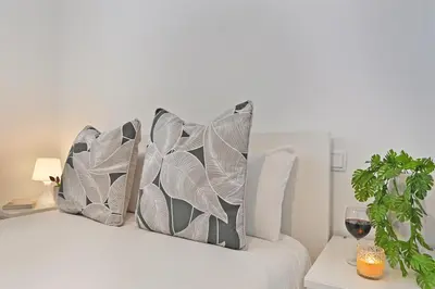 a bed with pillows on it with a glass of wine at Crystal Palace House - D19 in Porto