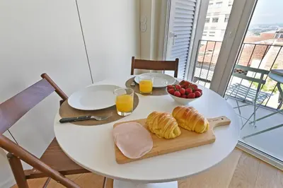 a white table with a plate of food and orange juice at Vera Cruz Porto Apartment in Porto
