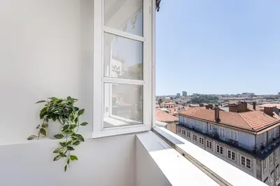 an open window with a plant on a white wall at GuestReady - RNB Apartments in Porto