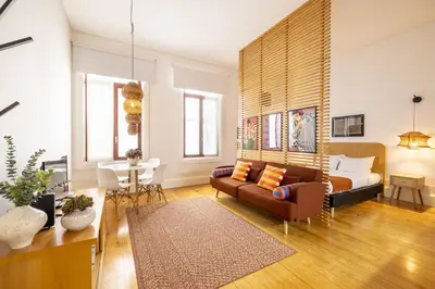a living room with a couch and a bed at Porto Ribeira Flat in Porto