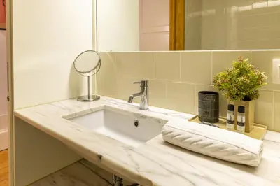 a bathroom counter with a sink and a mirror at Porto Ribeira Flat in Porto