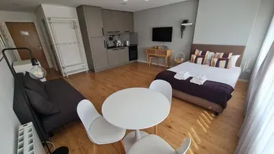 a bedroom with a bed and a table and chairs at Campanhã - Studio A in Porto