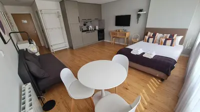 a bedroom with a bed and a table and chairs at Campanhã - Studio A in Porto