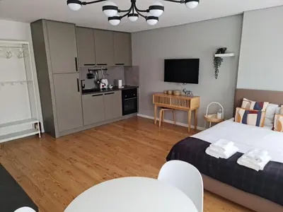 a bedroom with a large bed and a kitchen at Campanhã - Studio A in Porto