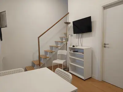 a room with a staircase with a tv and a table and chairs at Original Porto - Cedofeita in Porto