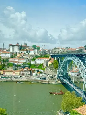 a bridge over a river next to a city at The Arcada House by MyMoradia in Porto