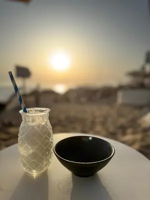 a bowl and a glass vase on a table with the sunset at The Arcada House by MyMoradia in Porto