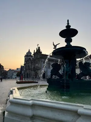 a fountain in the middle of a city with a building at The Arcada House by MyMoradia in Porto