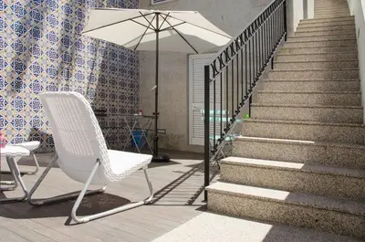 a chair and an umbrella next to a staircase at Porto Náutico & Spa in Porto