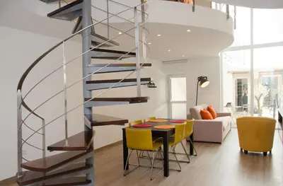 a staircase in a living room with a table and yellow chairs at Porto Náutico & Spa in Porto