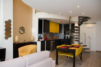 a kitchen and living room with a table and yellow chairs at Porto Náutico & Spa in Porto