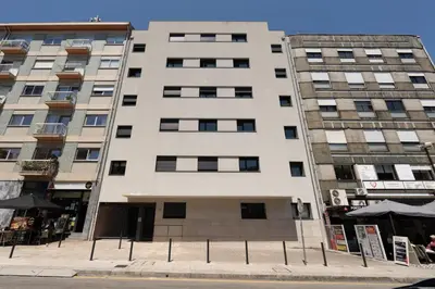 a tall white building on the corner of a street at HostWise - Modern Flat in Boavista in Porto