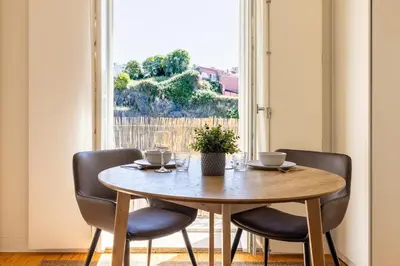 a dining room table with two chairs and a window at Central charming flat SÉ by casaporto207 in Porto