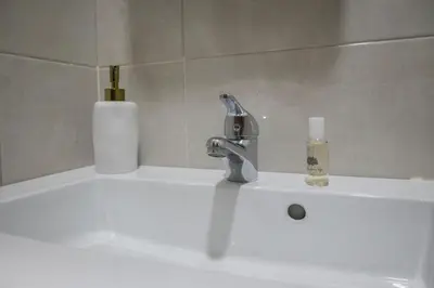a bathroom sink with a faucet and a soap bottle at Aposentus - Cest La Vie in Porto