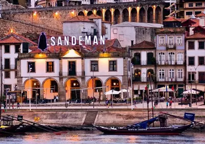a group of buildings with a boat in the water at Cais das Flores in Vila Nova de Gaia