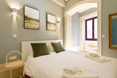 a bedroom with a large white bed and a window at Aposentus - Formosa Boutique in Porto
