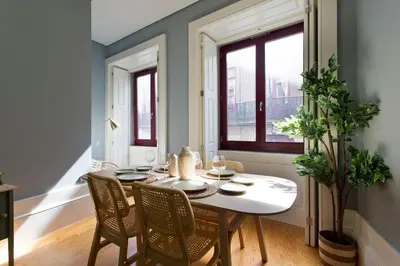 a dining room with a table and chairs and a window at Aposentus - Formosa Boutique in Porto