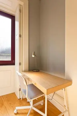 a desk in a room with a chair and a lamp at Aposentus - Formosa Boutique in Porto