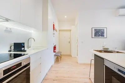 a kitchen with white cabinets and a wooden floor at GuestReady - A lovely stay in Rua da Boavista in Porto
