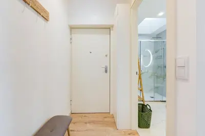 a white hallway with a door and a chair at GuestReady - A lovely stay in Rua da Boavista in Porto