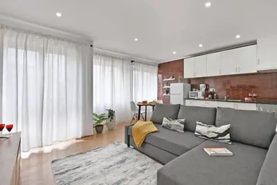 a living room with a gray couch and a kitchen at Apartamento Ponte D Luís in Vila Nova de Gaia