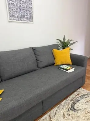 a living room with a gray couch and a flat screen tv at Apartamento Ponte D Luís in Vila Nova de Gaia