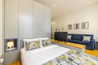 a bedroom with a bed and a blue couch at 741 Studio By D&S in Porto