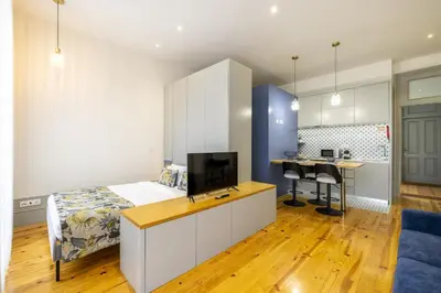 a bedroom with a bed and a desk with a tv at 741 Studio By D&S in Porto