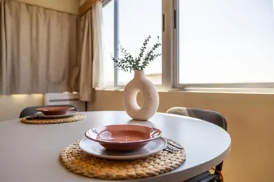 a table with two plates and a vase on it at Skyline Porto Apartment - Porto Velho Apt in Porto