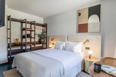 a bedroom with a large white bed and a table at Regras Apartments & Garden by Benefit Collection B in Porto