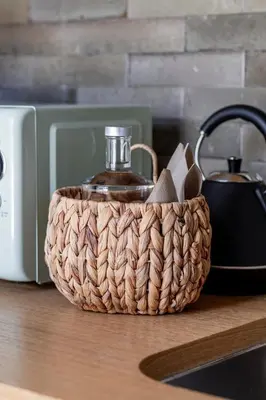 a basket with a bottle of oil on top of a counter at Regras Apartments & Garden by Benefit Collection B in Porto