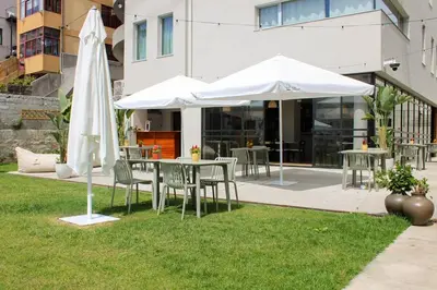 a patio with tables and umbrellas on the grass at Regras Apartments & Garden by Benefit Collection B in Porto