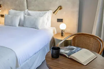a hotel room with a bed and a book on a table at Regras Apartments & Garden by Benefit Collection B in Porto