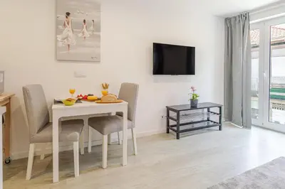 a dining room with a table and chairs and a tv at HostWise - Modern & Bright Studio in Porto