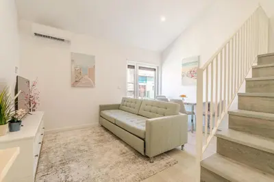 a living room with a couch and stairs at HostWise - Modern & Bright Studio in Porto